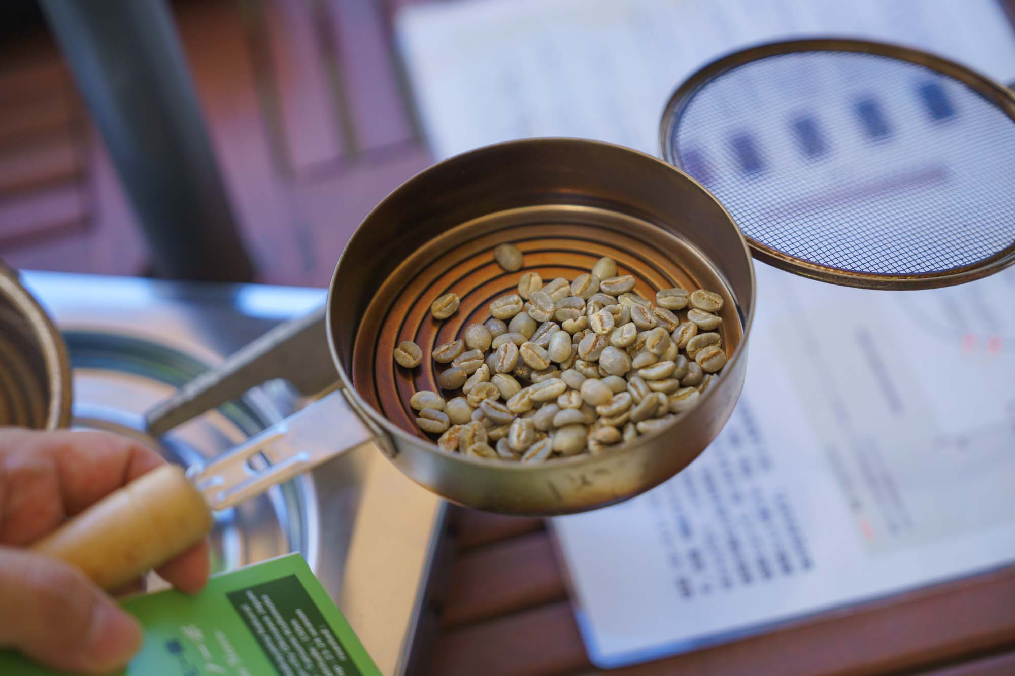 Roast the raw beans over the fire shaking the pan gently from side to side.